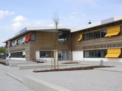 Förderschule Illertissen mit Holzlamellenfassade und gelben Sonnenschutzmarkisen